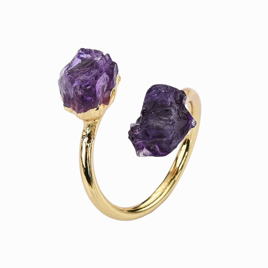 Gold ring with purple gemstones on a white background