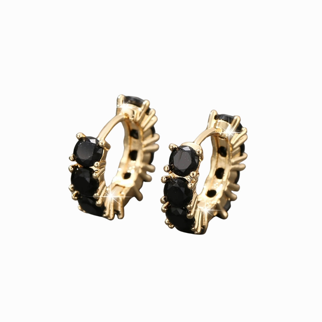 Gold hoop earrings with black gemstones on a white background