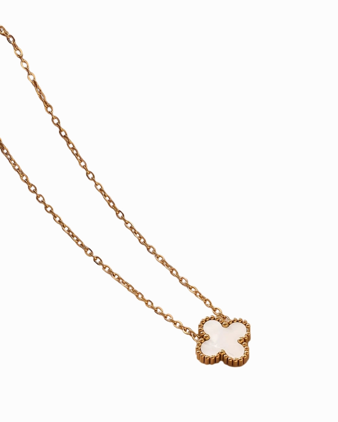 Gold necklace with a clover-shaped pendant on a white background