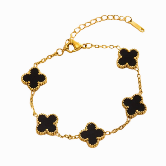 Gold bracelet with black clover-shaped charms on a white background