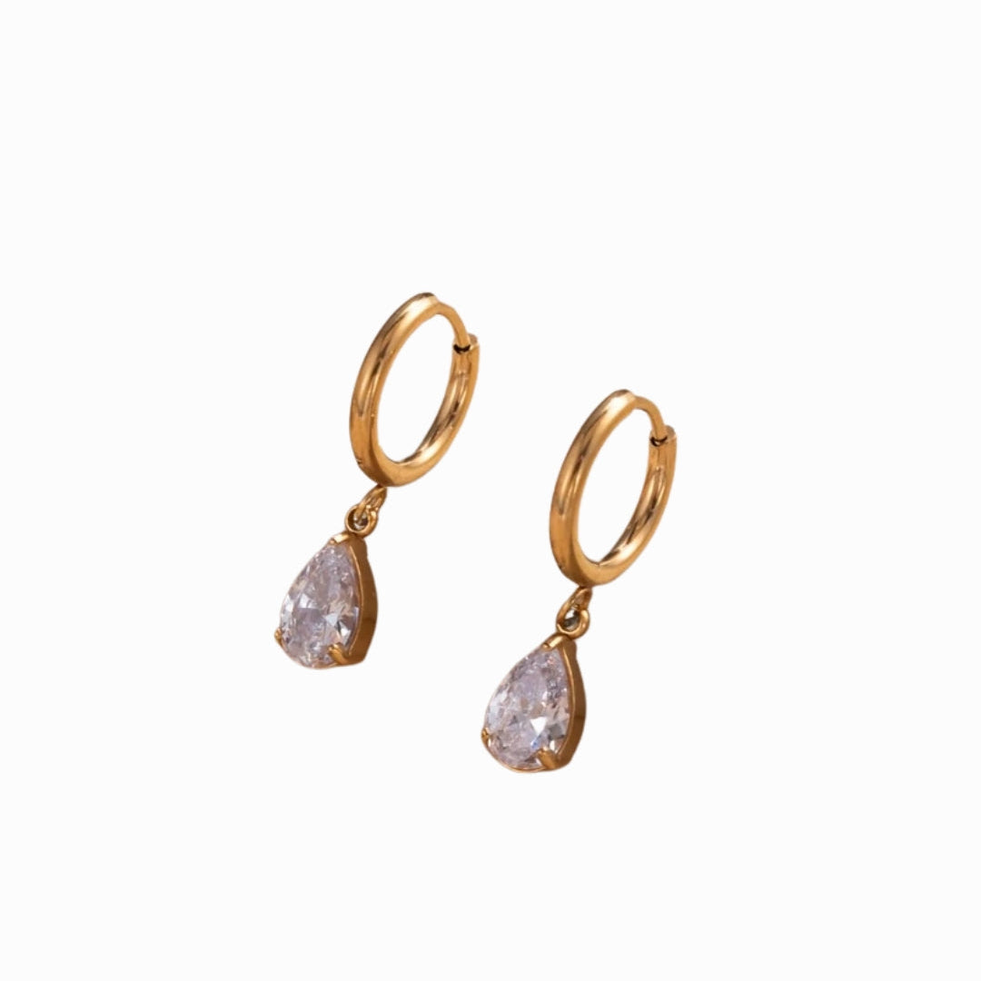 Gold hoop earrings with teardrop-shaped clear gemstones on a white background