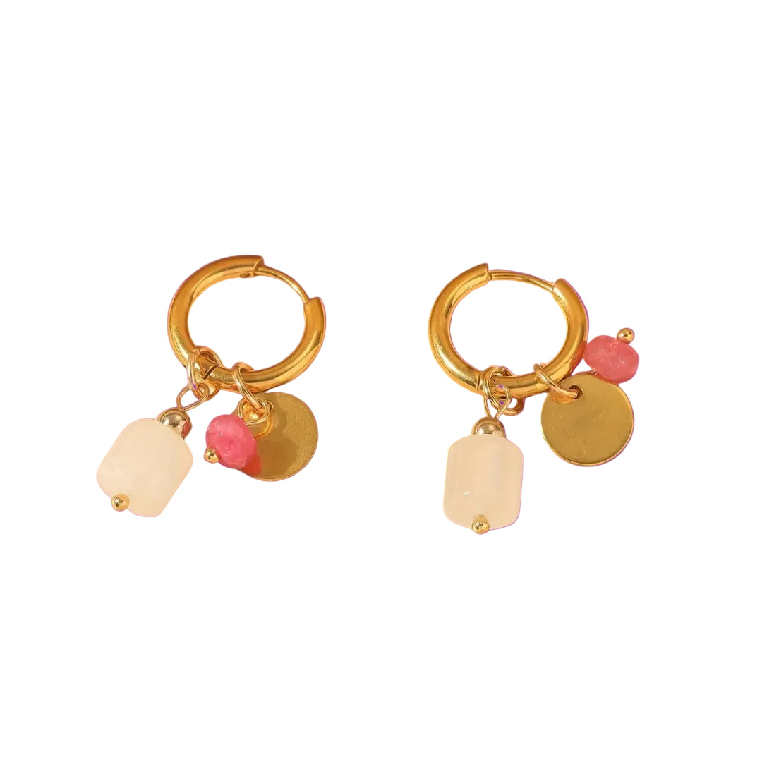 Gold hoop earrings with colorful charms on a purple background
