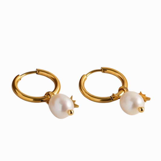 Gold hoop earrings with pearl drops on a white background