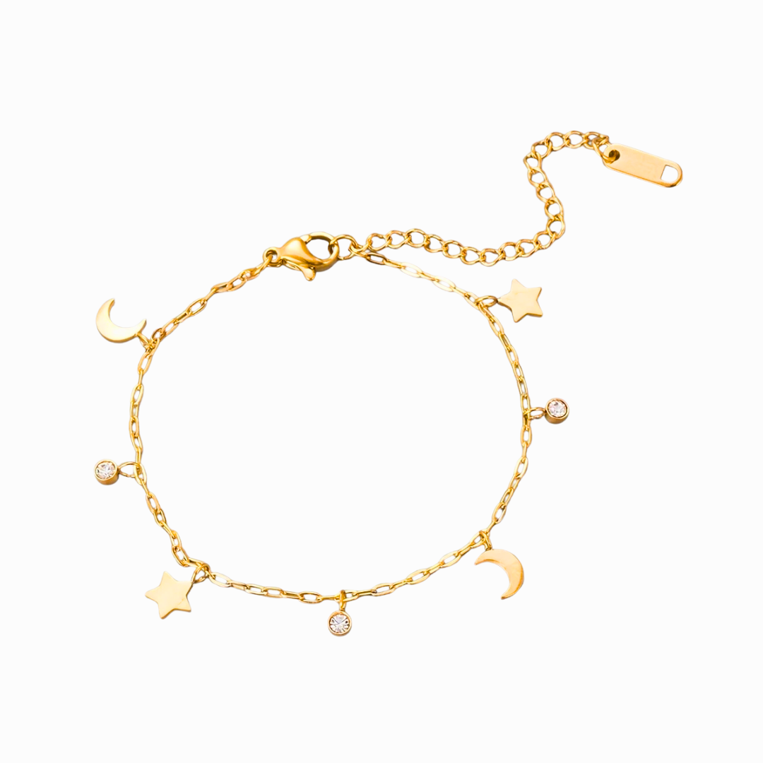 Gold bracelet with star and moon charms on a white background