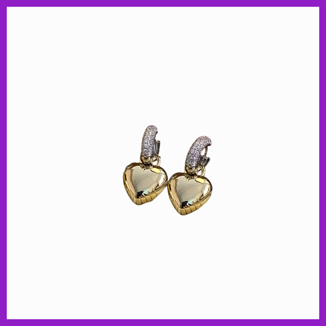 Heart-shaped earrings with gold and clear gemstones on a white background