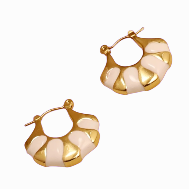 Gold hoop earrings with a white pattern on a white background
