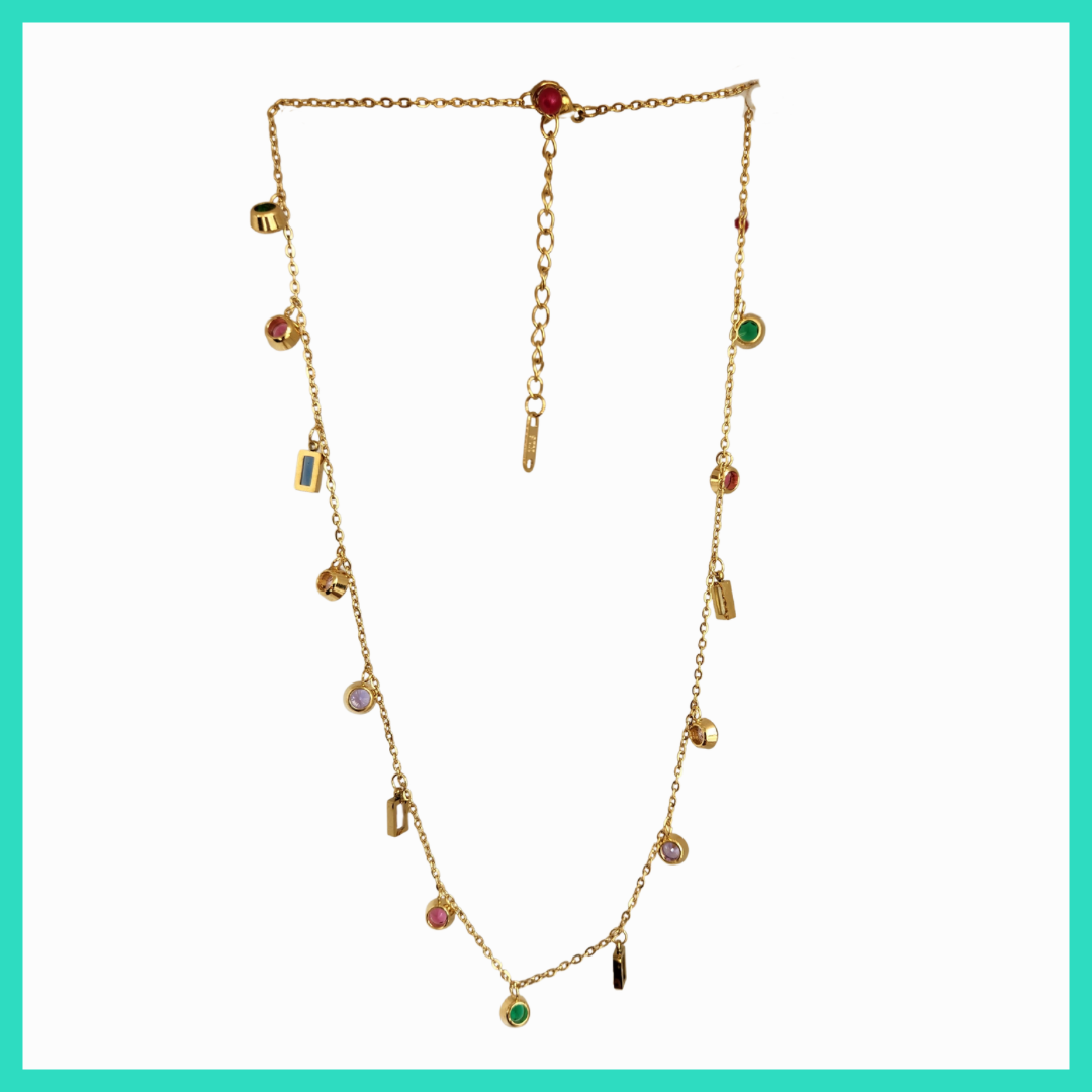 Gold necklace with colorful gemstones on a light green background
