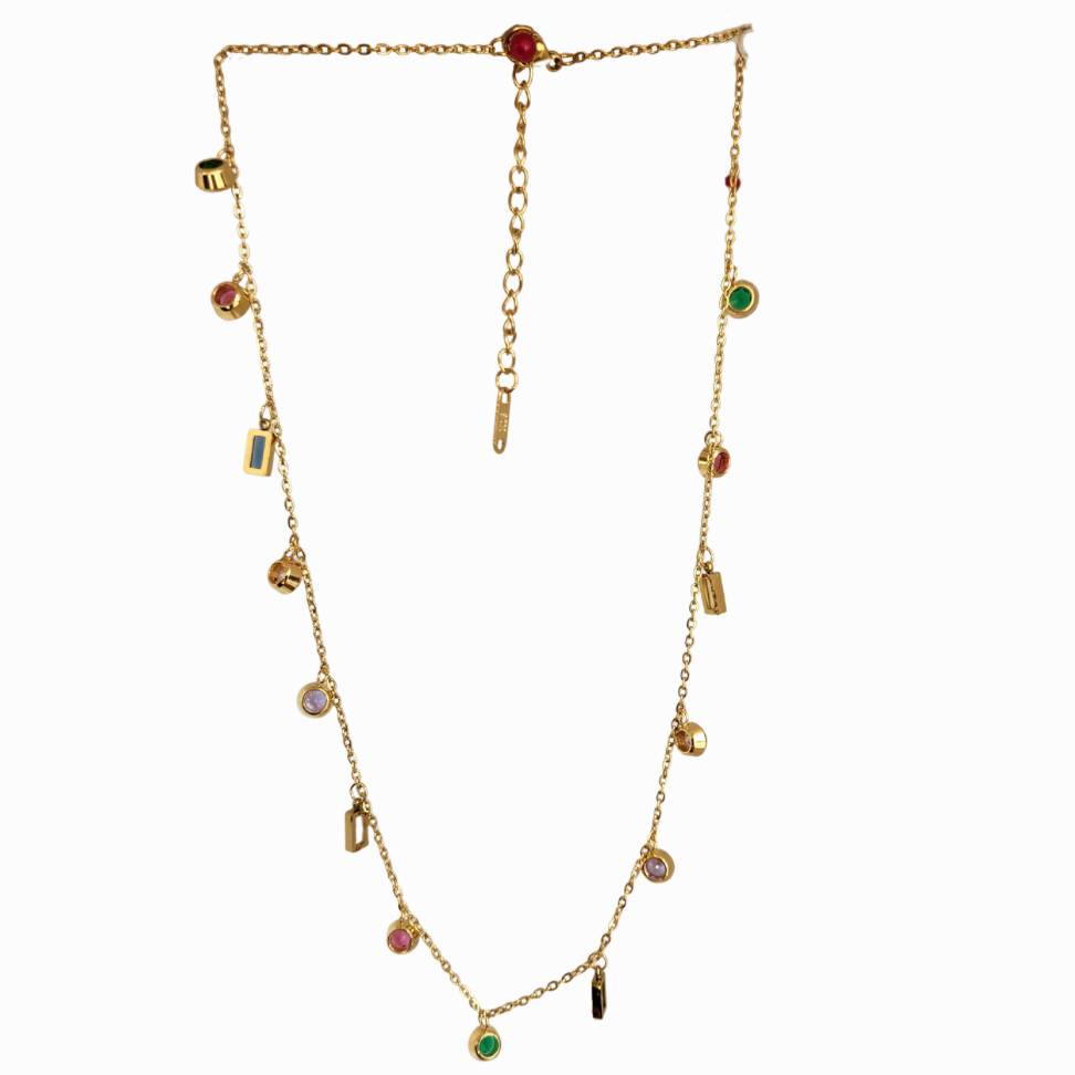 Gold necklace with colorful gemstones on a light green background