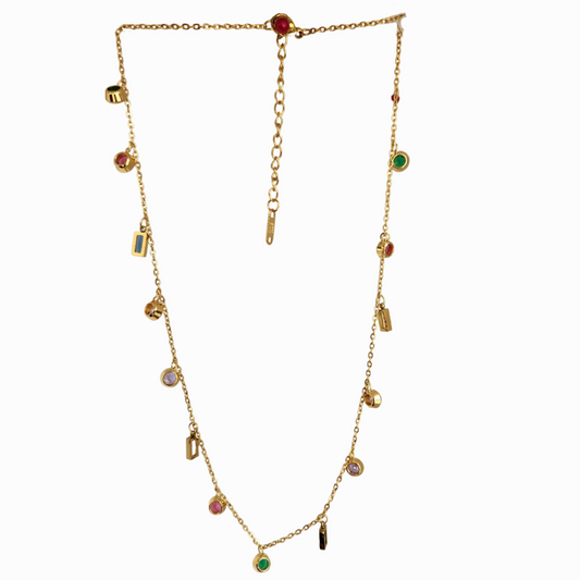 Gold necklace with colorful gemstones on a light green background