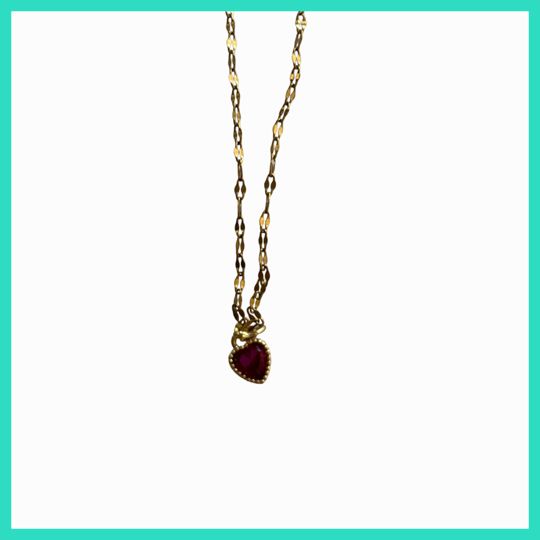 Gold necklace with a red pendant on a white background
