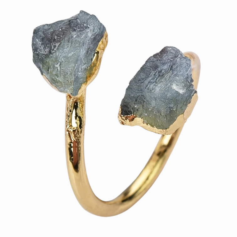 Gold ring with raw gemstones on a white background