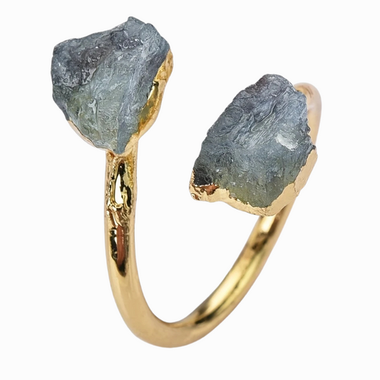 Gold ring with raw gemstones on a white background
