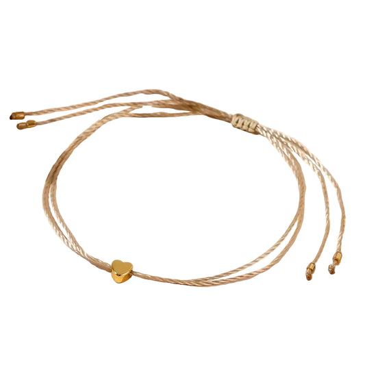A handcrafted boho chic braided bracelet with mini love heart beads in an elegant golden color, displayed on a neutral background.