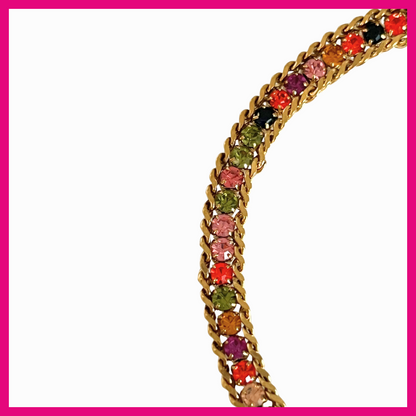 Gold bracelet with colorful gemstones on a white background