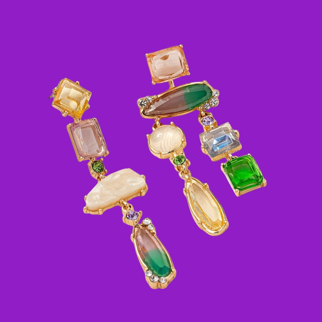 Multicolored gemstone earrings on a purple background
