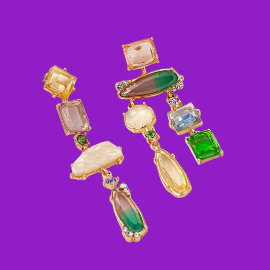Multicolored gemstone earrings on a purple background