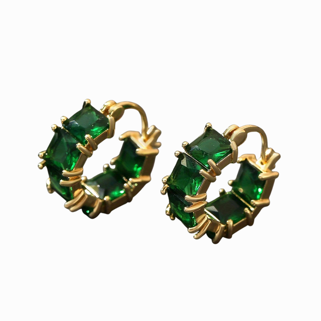 Gold hoop earrings with green gemstones on a white background