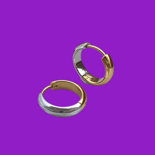 Two-tone hoop earrings, gold and silver, on a purple background