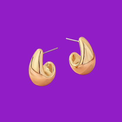 Gold hoop earrings on a purple background