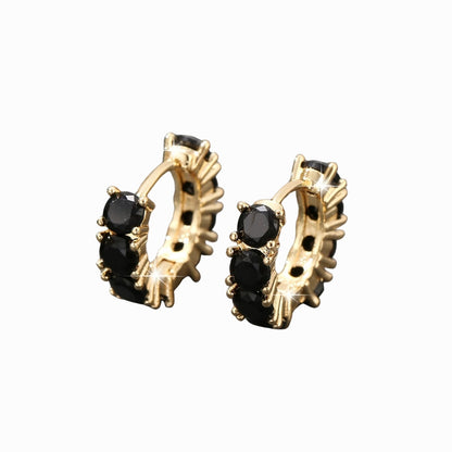 Gold hoop earrings with black gemstones on a white background