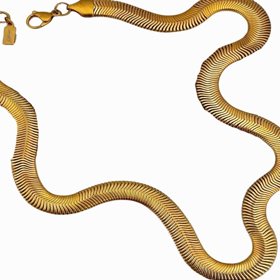 Gold snake-shaped necklace on a white background