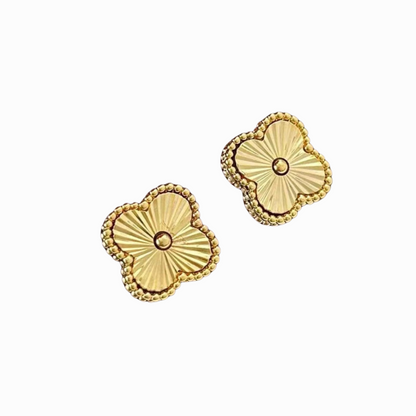 Pair of gold floral earrings on a white background