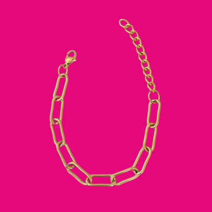 Gold chain necklace on a pink background