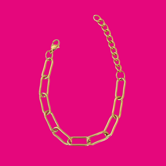 Gold chain necklace on a pink background