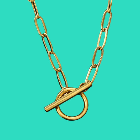 Gold chain necklace with a clasp on a turquoise background