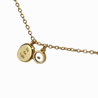 Gold necklace with two round pendants on a white background
