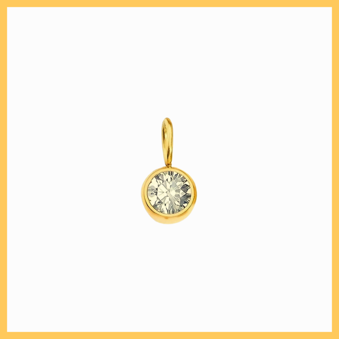 Gold pendant with a clear gemstone on a white background