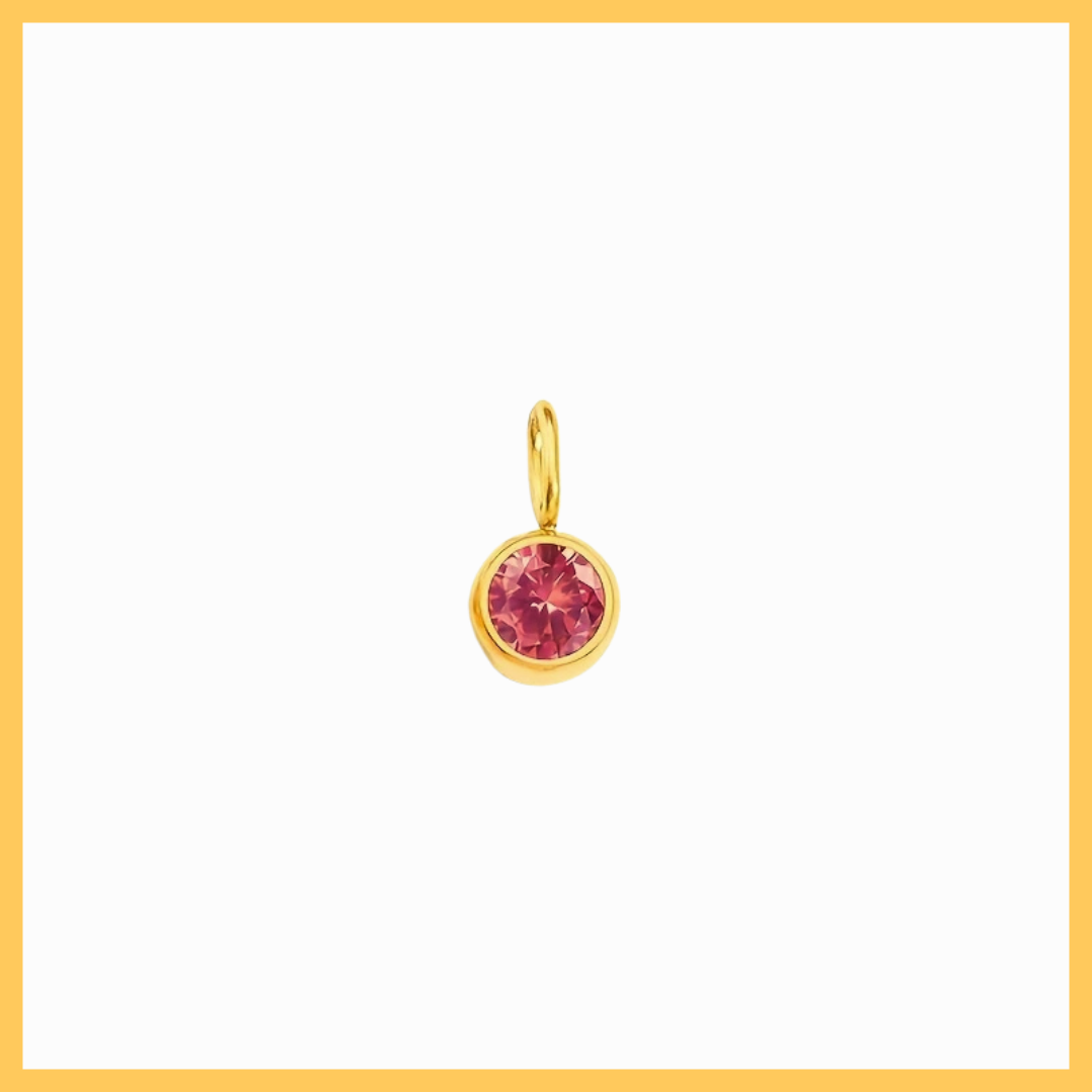 Gold pendant with a red gemstone on a white background