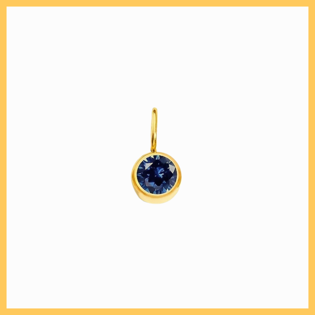 Gold pendant with a blue gemstone on a white background