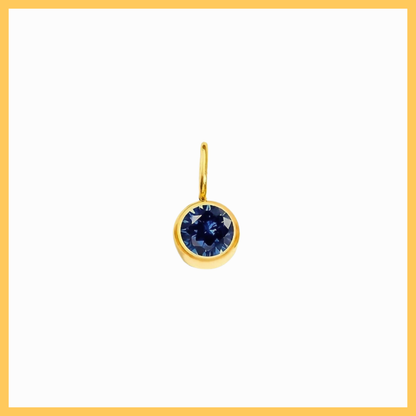 Gold pendant with a blue gemstone on a white background