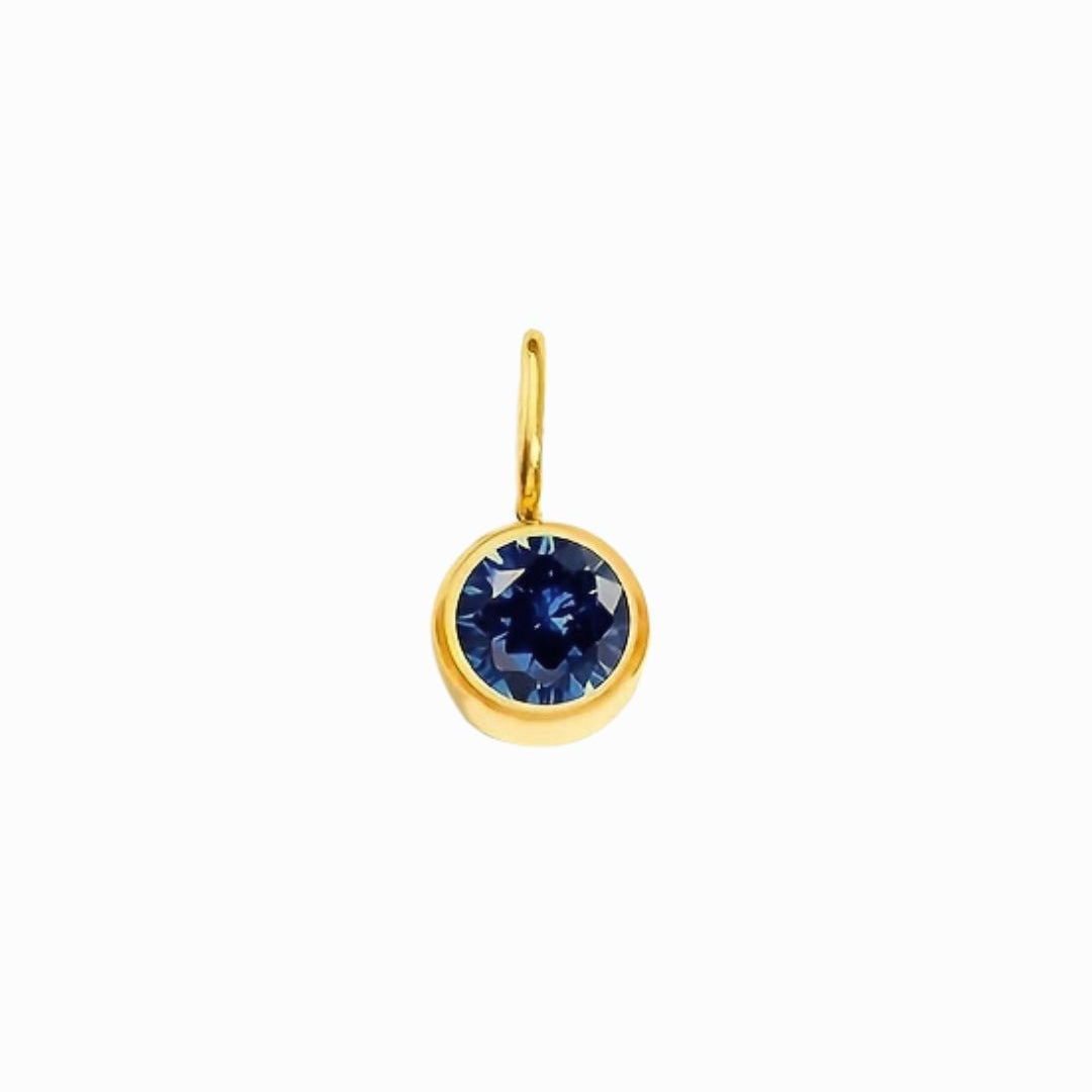 Gold earring with a blue gemstone on a white background