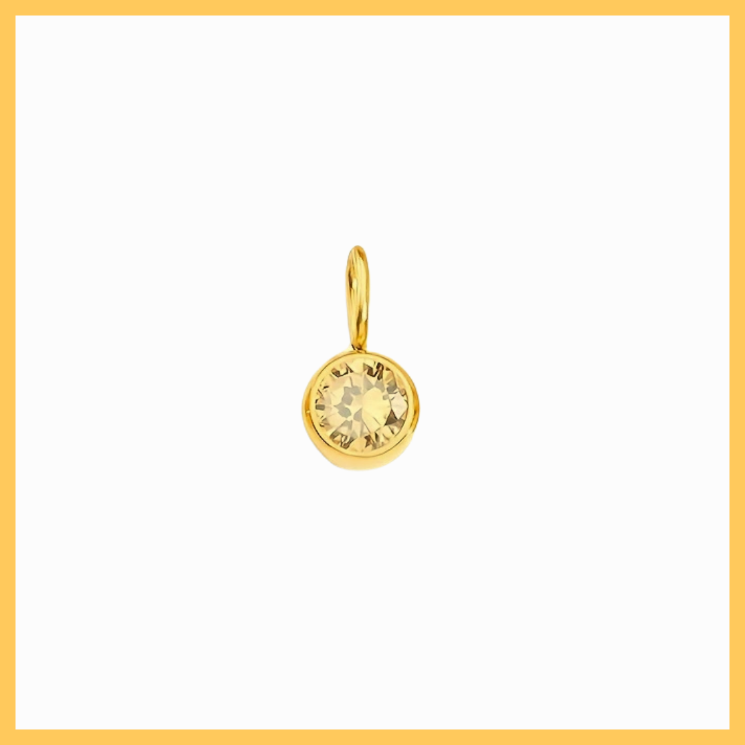 Gold pendant with a clear gemstone on a white background