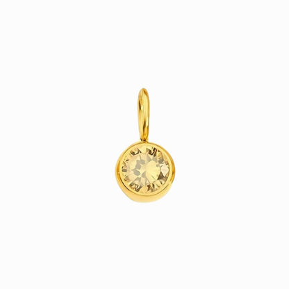 Gold pendant with a yellow gemstone on a white background