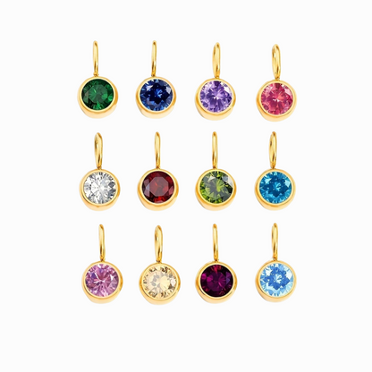 Set of gold charms with colorful gemstones on a white background