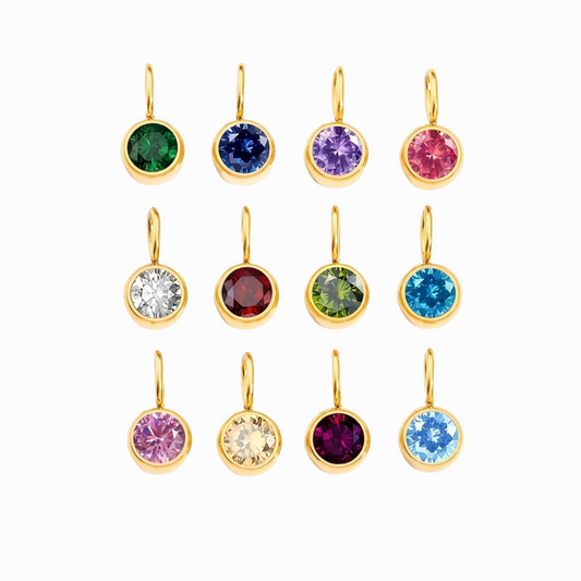 Set of gold charms with colorful gemstones on a white background