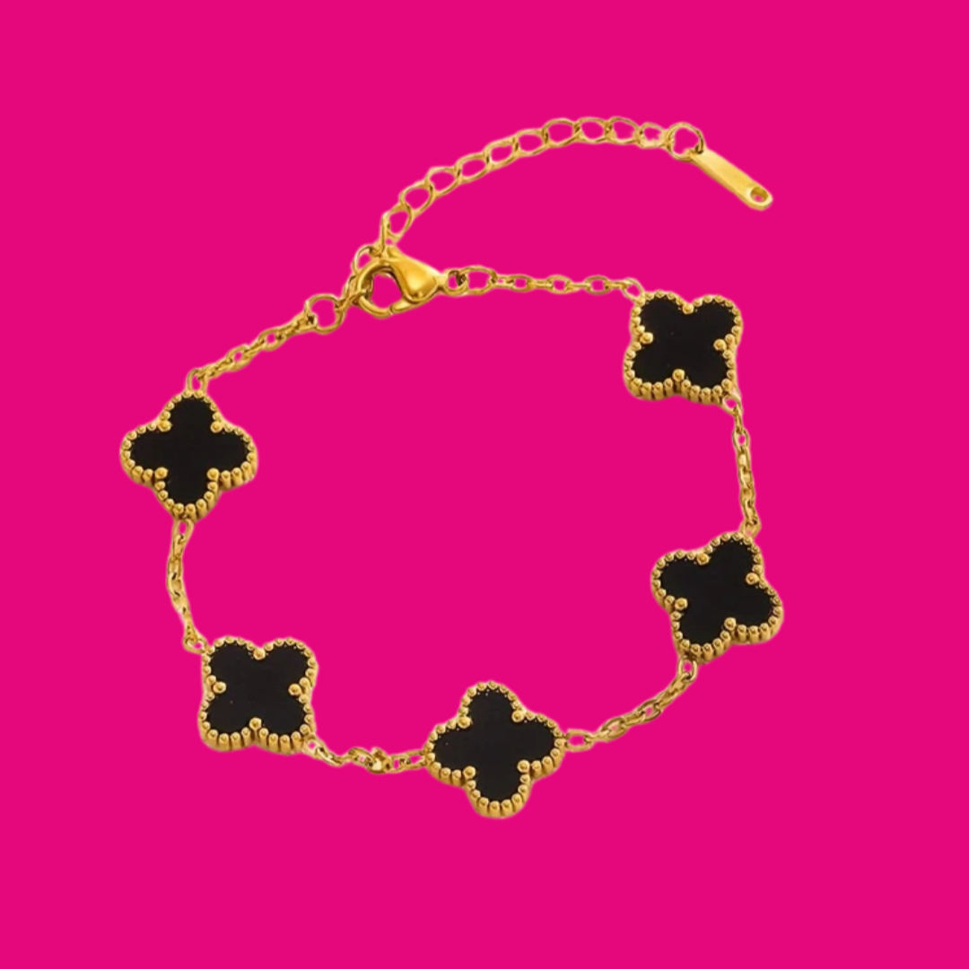 Gold bracelet with black clover-shaped charms on a pink background