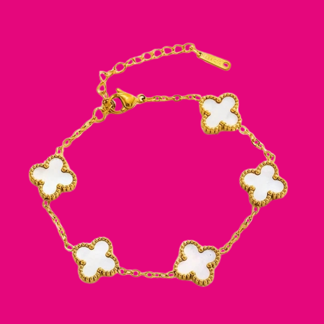 Gold bracelet with white clover-shaped charms on a pink background