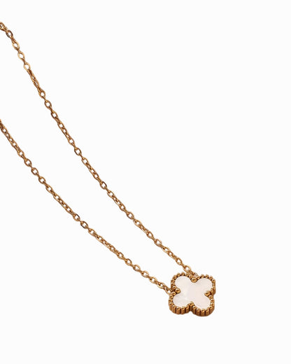 Gold necklace with a clover-shaped pendant on a white background