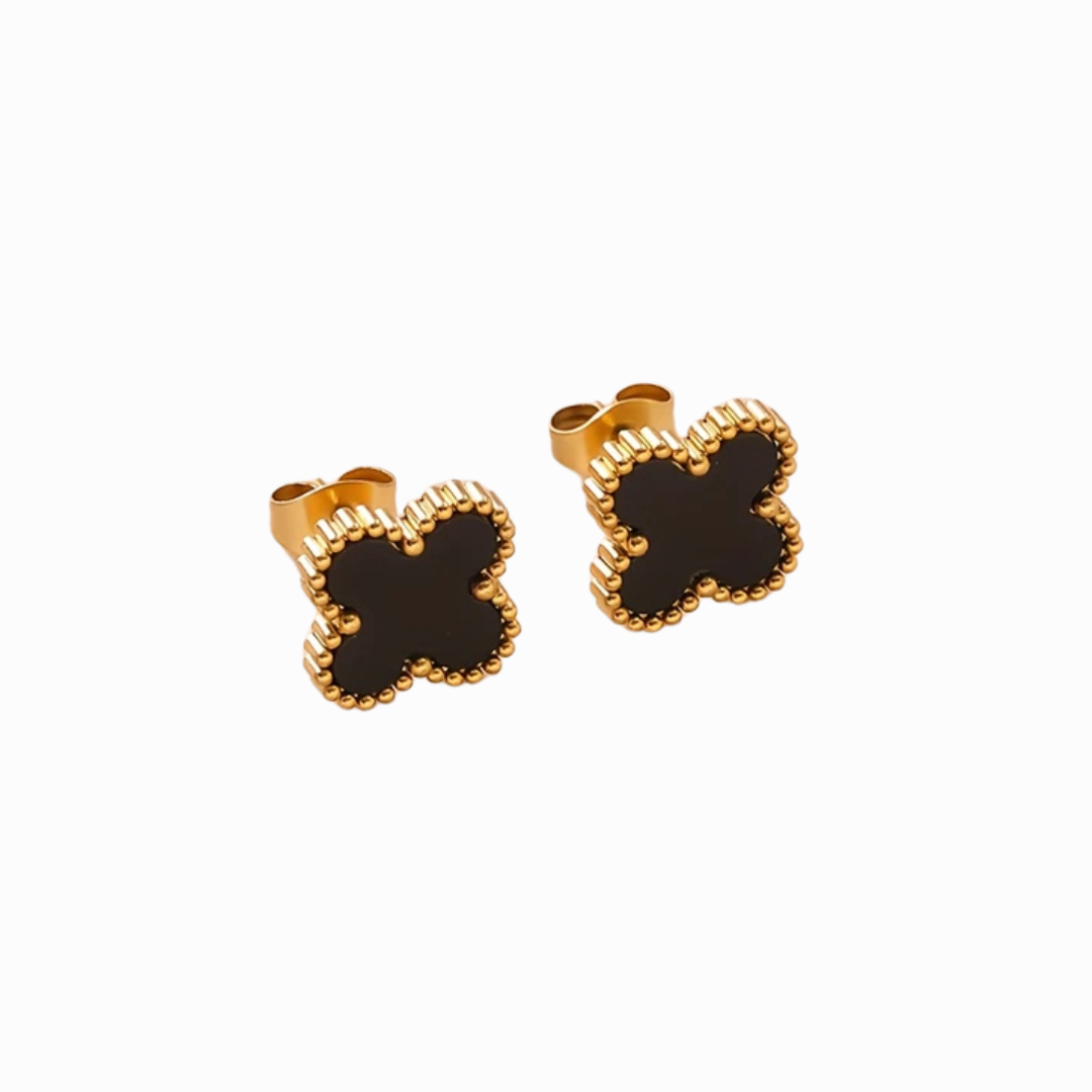 Pair of gold and black four-leaf clover earrings on a white background
