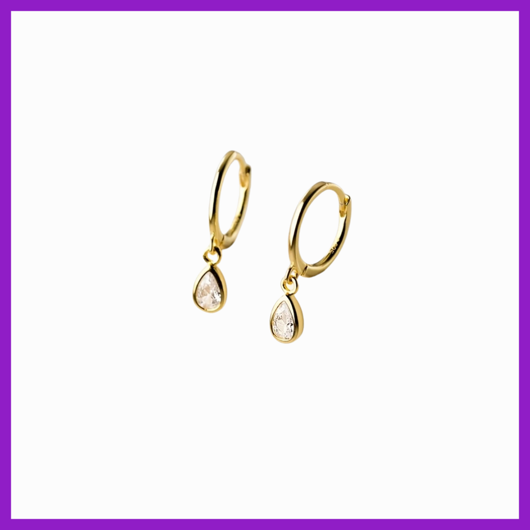 Gold earrings with clear stones on a white background
