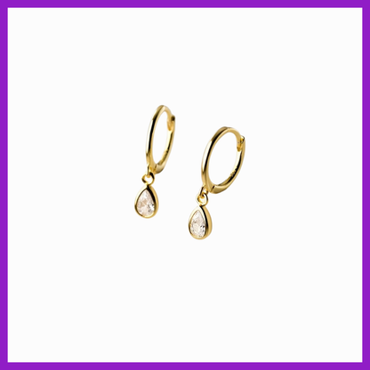 Gold earrings with clear stones on a white background