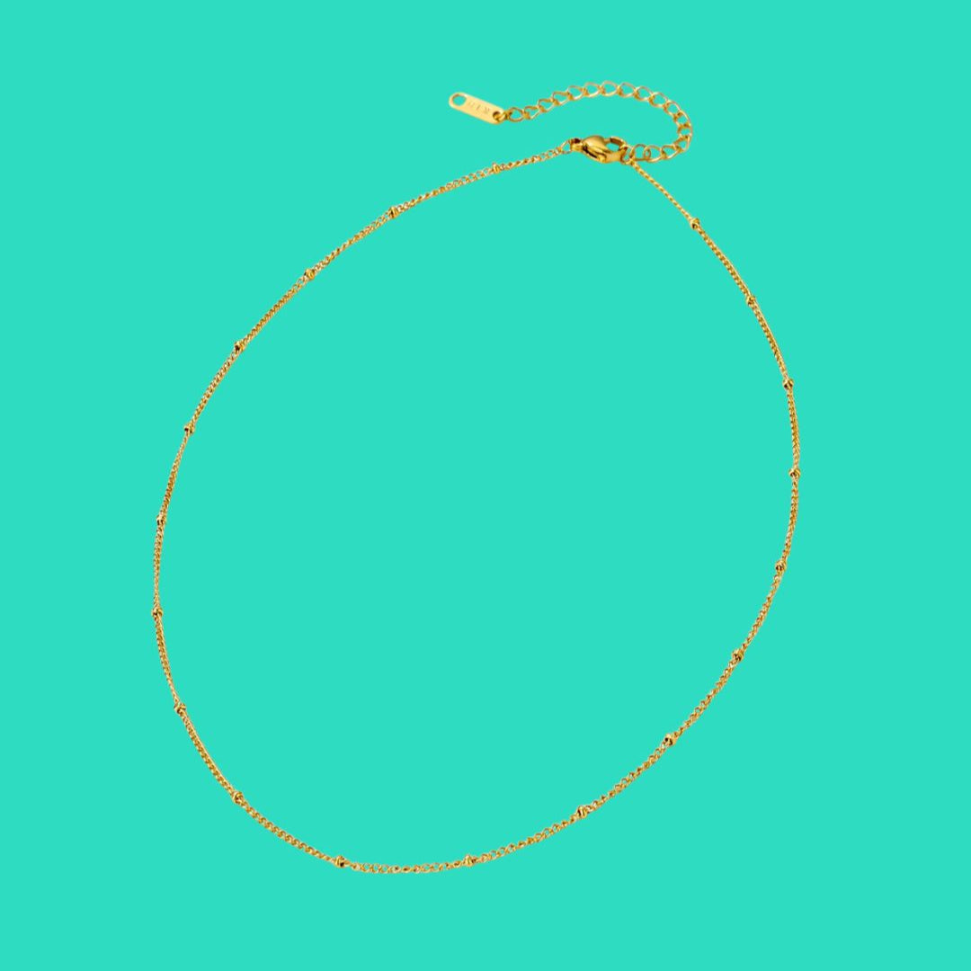 Gold necklace on a turquoise background
