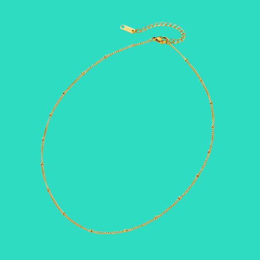Gold necklace on a turquoise background