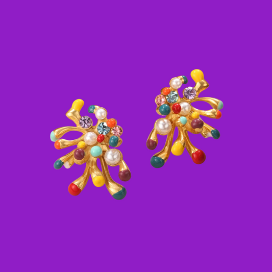 Close-up of bold colourful earrings with pearls and gems.