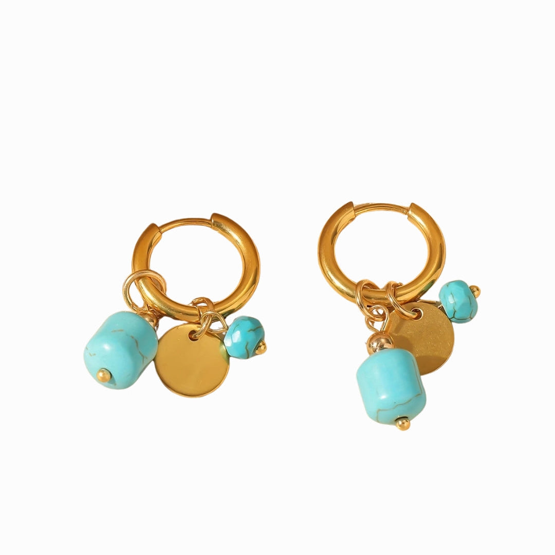 Pair of gold hoop earrings with turquoise beads on a white background