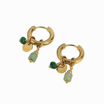 Gold hoop earrings with green beads on a white background